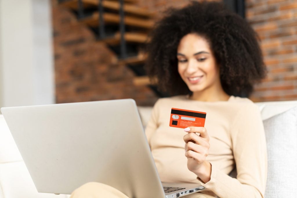 Well-dressed latin woman paying online by credit card