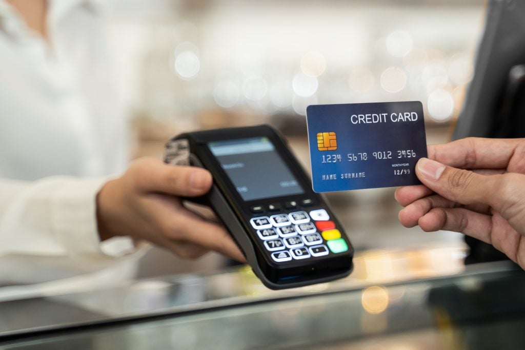 Customer using credit card for payment at cashier in cafe restau